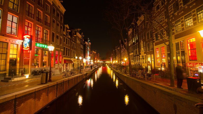 Dzielnica czerwonych latarni w Amsterdamie podczas nocnego widoku na kanał