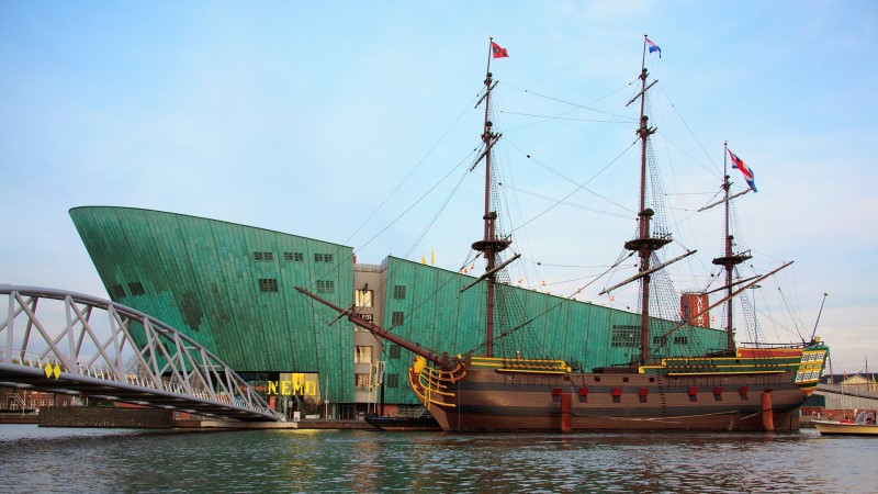 Ein Schiff vor dem Amsterdamer Wissenschaftsmuseum NEMO