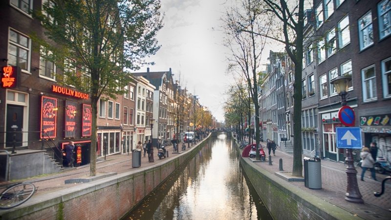 Dzielnica czerwonych latarni w Amsterdamie za dnia z widokiem na kanał