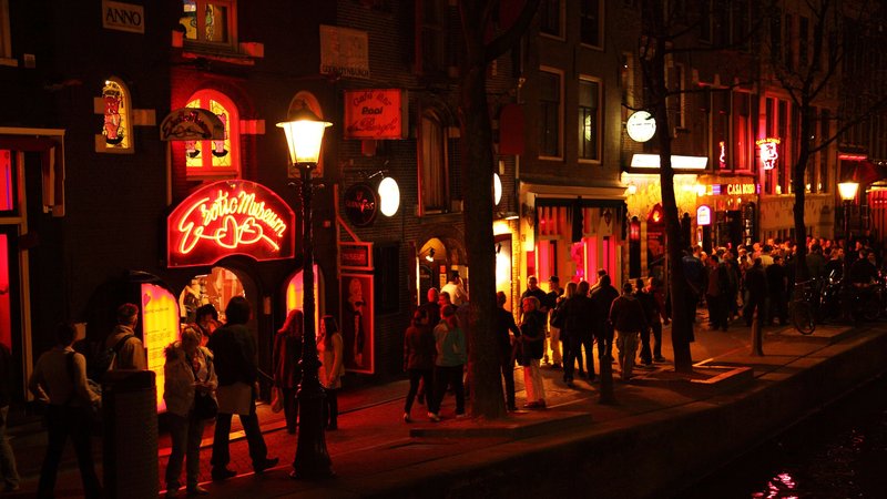 Dzielnica czerwonych latarni w Amsterdamie nocą, ruchliwa ulica z ludźmi