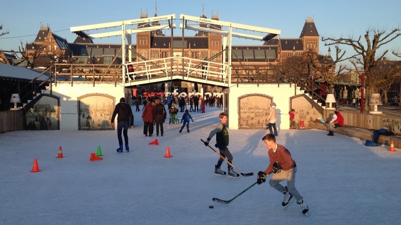 Winter in Amsterdam kids playing hockey on canals