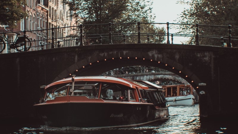 amsterdam canal cruise tour during evening under bridge