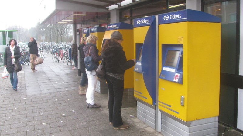 люди покупают билеты в автоматах по продаже билетов на общественный транспорт в Амстердаме